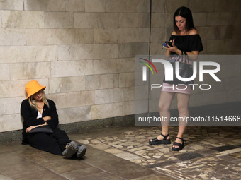 Two women stand at the Osokorky metro station during the massive Russian drone and missile attack on Ukraine in Kyiv, Ukraine, on August 26,...