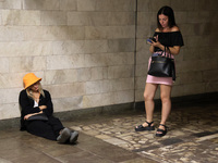 Two women stand at the Osokorky metro station during the massive Russian drone and missile attack on Ukraine in Kyiv, Ukraine, on August 26,...