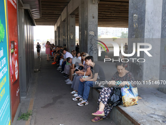 People stand under an overpass during the massive Russian drone and missile attack in Kyiv, Ukraine, on August 26, 2024. NO USE RUSSIA. NO U...