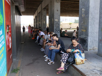 People stand under an overpass during the massive Russian drone and missile attack in Kyiv, Ukraine, on August 26, 2024. NO USE RUSSIA. NO U...