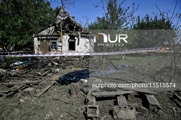 The body of a man killed by the Russian missile attack is on the ground in the human remains pouch outside his house in Zaporizhzhia region,...