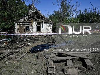 The body of a man killed by the Russian missile attack is on the ground in the human remains pouch outside his house in Zaporizhzhia region,...