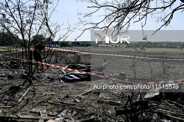 The body of a man killed by the Russian missile attack is on the ground in the human remains pouch outside his house in Zaporizhzhia region,...