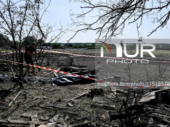 The body of a man killed by the Russian missile attack is on the ground in the human remains pouch outside his house in Zaporizhzhia region,...