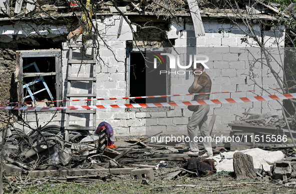 An elderly woman stands outside a house after the owner is killed by a Russian missile attack in the Zaporizhzhia region, Ukraine, on August...