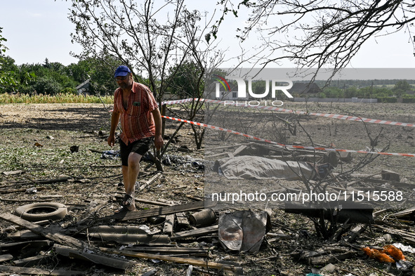 A man walks away from the body in the human remains pouch outside the victim's house after the fatal Russian missile attack in Zaporizhzhia...