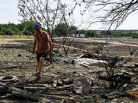 A man walks away from the body in the human remains pouch outside the victim's house after the fatal Russian missile attack in Zaporizhzhia...