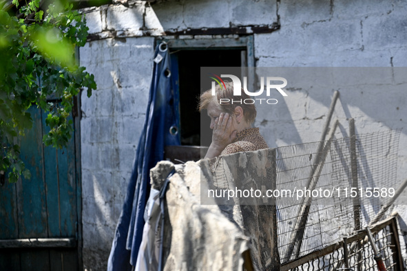 An elderly woman stands outside a house after the owner is killed by a Russian missile attack in the Zaporizhzhia region, Ukraine, on August...