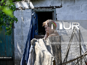 An elderly woman stands outside a house after the owner is killed by a Russian missile attack in the Zaporizhzhia region, Ukraine, on August...