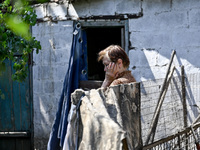 An elderly woman stands outside a house after the owner is killed by a Russian missile attack in the Zaporizhzhia region, Ukraine, on August...