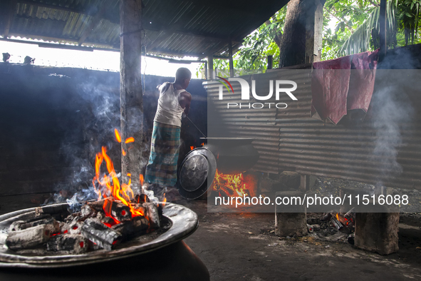 A cook prepares lunch for flood-affected people in the Aburhat area of Mirsharai Upazila, Chittagong Division, Bangladesh, on August 26, 202...