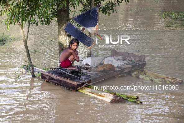 A small child sits on a banana raft in the Aburhat area of Mirsarai Upazila, Chittagong Division, Bangladesh, on August 26, 2024. At least 1...