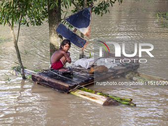 A small child sits on a banana raft in the Aburhat area of Mirsarai Upazila, Chittagong Division, Bangladesh, on August 26, 2024. At least 1...