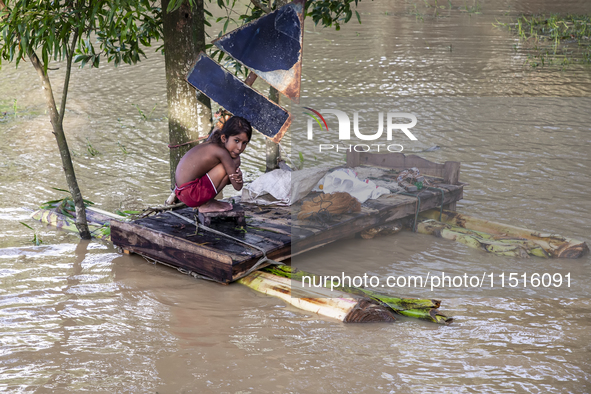 A small child sits on a banana raft in the Aburhat area of Mirsarai Upazila, Chittagong Division, Bangladesh, on August 26, 2024. At least 1...