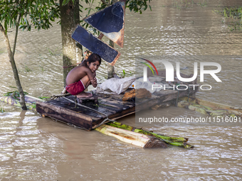 A small child sits on a banana raft in the Aburhat area of Mirsarai Upazila, Chittagong Division, Bangladesh, on August 26, 2024. At least 1...