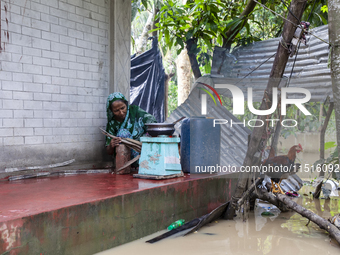 A woman cooks on a separate stove in front of her house due to floods in the Aburhat area of Mirsarai Upazila of Chittagong Division, Bangla...