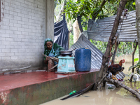 A woman cooks on a separate stove in front of her house due to floods in the Aburhat area of Mirsarai Upazila of Chittagong Division, Bangla...