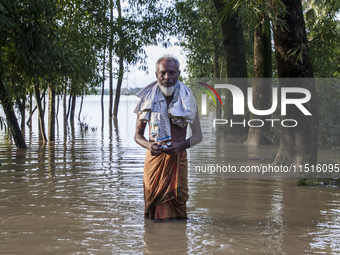 An elderly man stands on a flooded road in the Aburhat area of Mirsarai Upazila in Chittagong Division, Bangladesh, on August 26, 2024. At l...