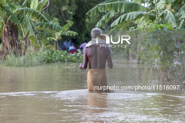 An elderly man walks through knee-deep flood water in the Aburhat area of Mirsarai Upazila in Chittagong Division, Bangladesh, on August 26,...