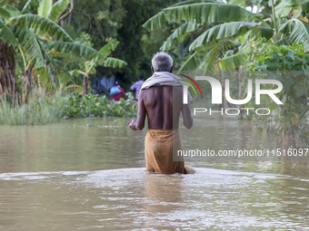 An elderly man walks through knee-deep flood water in the Aburhat area of Mirsarai Upazila in Chittagong Division, Bangladesh, on August 26,...