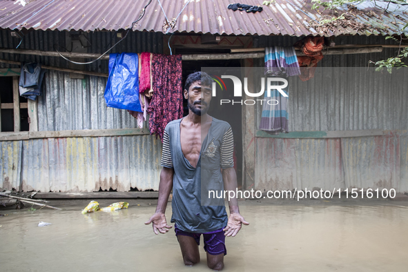 A man stands crying in front of his flooded house in the Aburhat area of Mirsarai Upazila in Chittagong Division, Bangladesh, on August 26,...