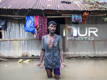 A man stands crying in front of his flooded house in the Aburhat area of Mirsarai Upazila in Chittagong Division, Bangladesh, on August 26,...