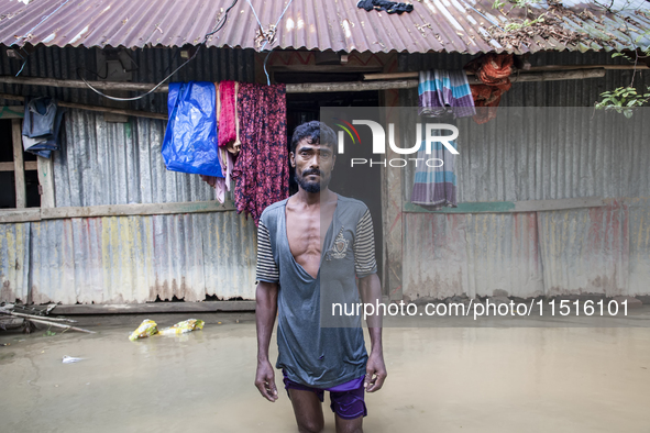 A man stands crying in front of his flooded house in the Aburhat area of Mirsarai Upazila in Chittagong Division, Bangladesh, on August 26,...