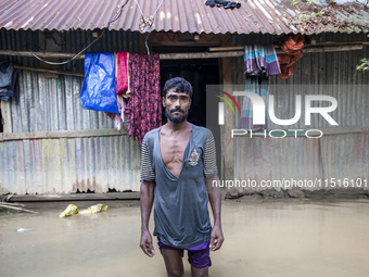 A man stands crying in front of his flooded house in the Aburhat area of Mirsarai Upazila in Chittagong Division, Bangladesh, on August 26,...