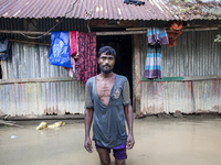 A man stands crying in front of his flooded house in the Aburhat area of Mirsarai Upazila in Chittagong Division, Bangladesh, on August 26,...