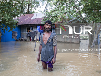 A man stands crying in front of his flooded house in the Aburhat area of Mirsarai Upazila in Chittagong Division, Bangladesh, on August 26,...