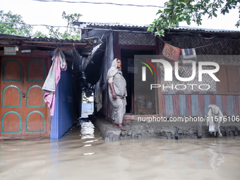 A woman stands in front of her flooded house in the Aburhat area of Mirsarai Upazila in Chittagong Division, Bangladesh, on August 26, 2024....