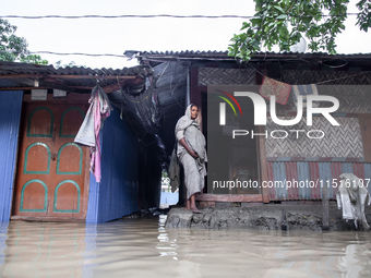 A woman stands in front of her flooded house in the Aburhat area of Mirsarai Upazila in Chittagong Division, Bangladesh, on August 26, 2024....