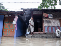 A woman stands in front of her flooded house in the Aburhat area of Mirsarai Upazila in Chittagong Division, Bangladesh, on August 26, 2024....