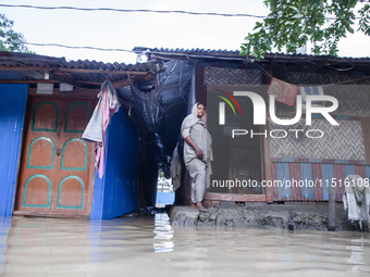 A woman stands in front of her flooded house in the Aburhat area of Mirsarai Upazila in Chittagong Division, Bangladesh, on August 26, 2024....