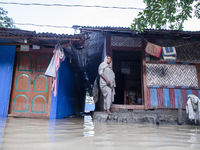 A woman stands in front of her flooded house in the Aburhat area of Mirsarai Upazila in Chittagong Division, Bangladesh, on August 26, 2024....