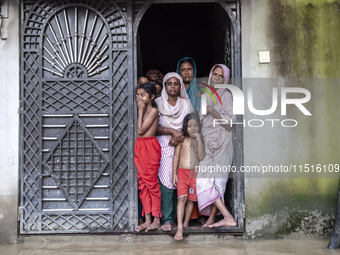 On August 26, 2024, in Mirsarai, Chittagong, Bangladesh, some female members of a family stand at the front gate of their flooded house in t...