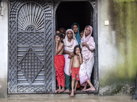 On August 26, 2024, in Mirsarai, Chittagong, Bangladesh, some female members of a family stand at the front gate of their flooded house in t...