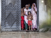 On August 26, 2024, in Mirsarai, Chittagong, Bangladesh, some female members of a family stand at the front gate of their flooded house in t...