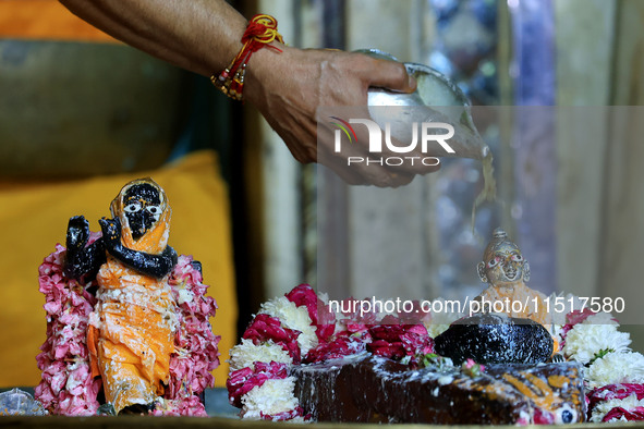 A priest performs 'Panchamrit Abhishek' at Radha Damodar Ji temple on the occasion of the Krishna Janmashtami festival in Jaipur, Rajasthan,...