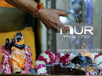 A priest performs 'Panchamrit Abhishek' at Radha Damodar Ji temple on the occasion of the Krishna Janmashtami festival in Jaipur, Rajasthan,...