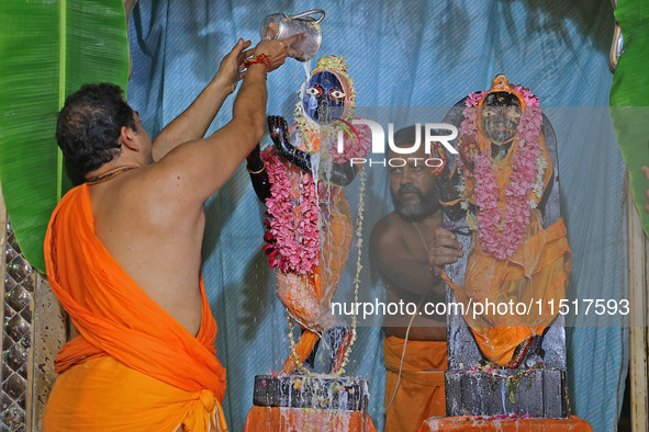 A priest performs 'Panchamrit Abhishek' at Radha Damodar Ji temple on the occasion of the Krishna Janmashtami festival in Jaipur, Rajasthan,...