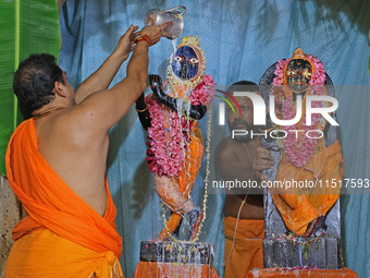 A priest performs 'Panchamrit Abhishek' at Radha Damodar Ji temple on the occasion of the Krishna Janmashtami festival in Jaipur, Rajasthan,...