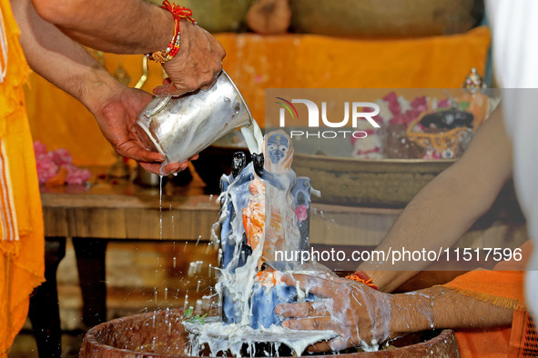 A priest performs 'Panchamrit Abhishek' at Radha Damodar Ji temple on the occasion of the Krishna Janmashtami festival in Jaipur, Rajasthan,...