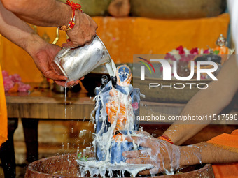 A priest performs 'Panchamrit Abhishek' at Radha Damodar Ji temple on the occasion of the Krishna Janmashtami festival in Jaipur, Rajasthan,...