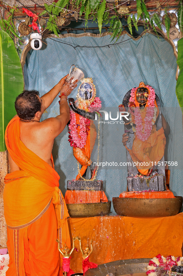 A priest performs 'Panchamrit Abhishek' at Radha Damodar Ji temple on the occasion of the Krishna Janmashtami festival in Jaipur, Rajasthan,...