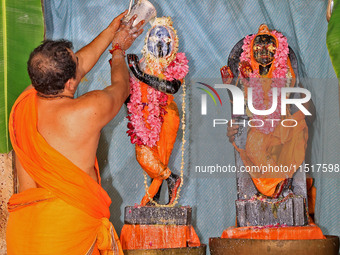 A priest performs 'Panchamrit Abhishek' at Radha Damodar Ji temple on the occasion of the Krishna Janmashtami festival in Jaipur, Rajasthan,...