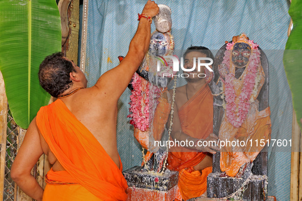 A priest performs 'Panchamrit Abhishek' at Radha Damodar Ji temple on the occasion of the Krishna Janmashtami festival in Jaipur, Rajasthan,...