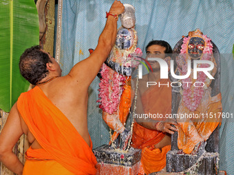 A priest performs 'Panchamrit Abhishek' at Radha Damodar Ji temple on the occasion of the Krishna Janmashtami festival in Jaipur, Rajasthan,...