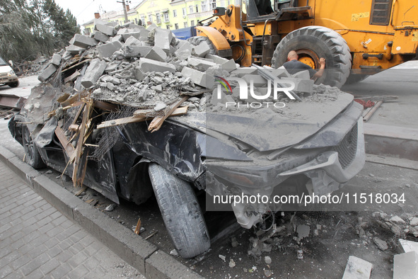 A crushed car is near a hotel destroyed by the Russian ballistic missile attack late on Monday, August 26, that claims the lives of two peop...