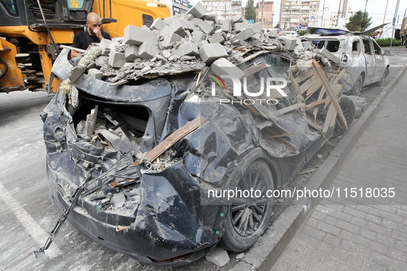 A crushed car is near a hotel destroyed by the Russian ballistic missile attack late on Monday, August 26, that claims the lives of two peop...